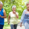 Three female seniors working out walking outdoors together