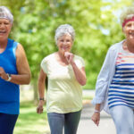 Three female seniors working out walking outdoors together
