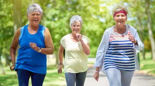 Three female seniors working out walking outdoors together