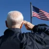 A veteran saluting to the US flag.