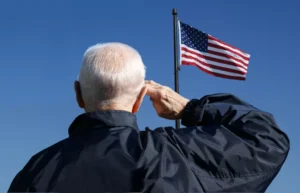 A veteran saluting to the US flag.