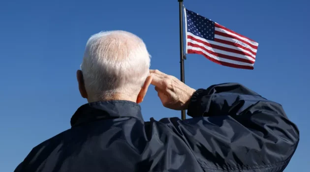 A veteran saluting to the US flag.