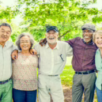 A group of seniors in an outdoor setting smiling.