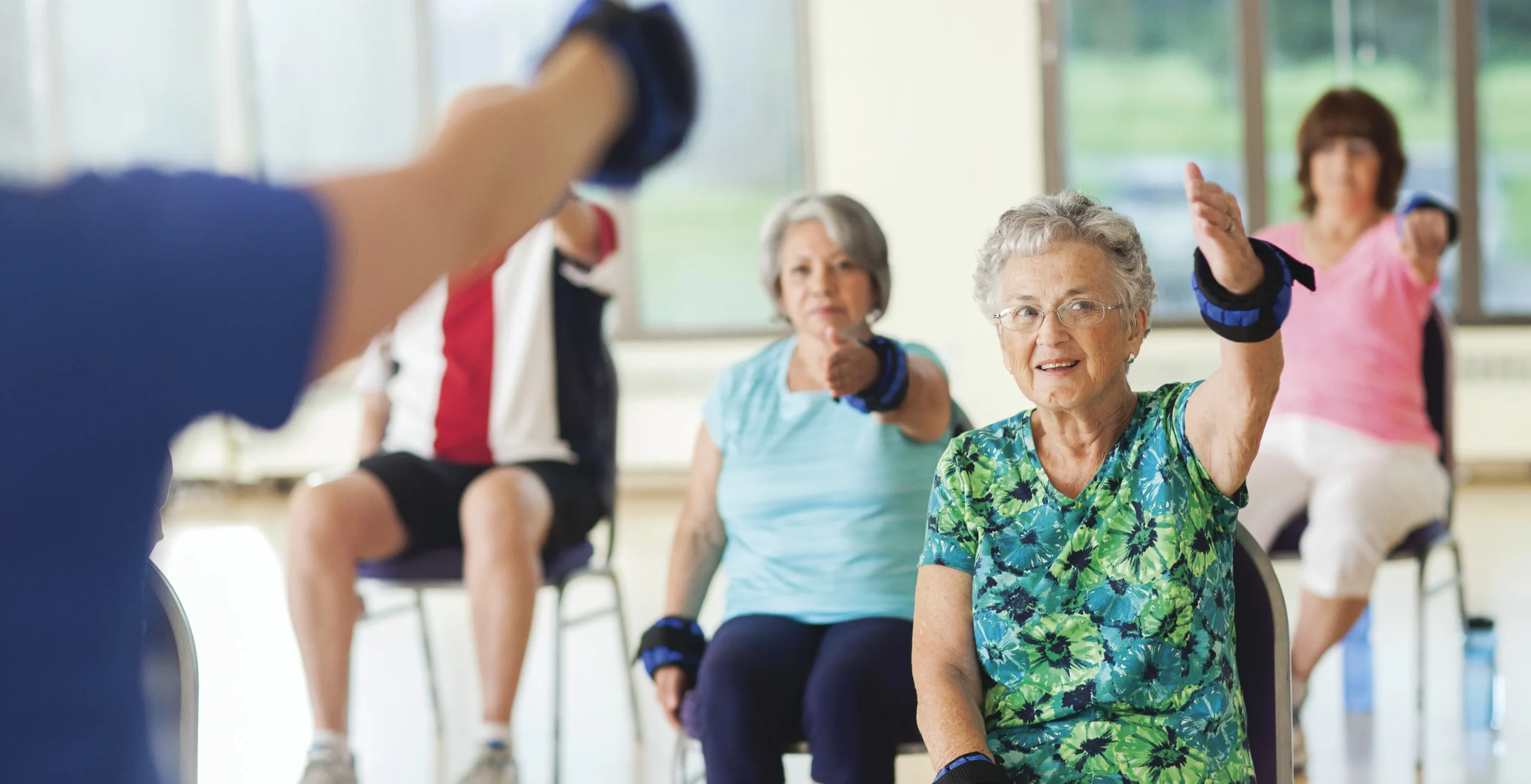 Seniors exercising in a group class setting.