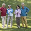 Two couples of seniors on a golf course ready to play.